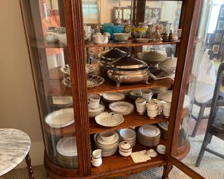 Bowfront China closet filled with lovely pieces of dinnerware
