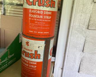 Three Orange Crush syrup cans