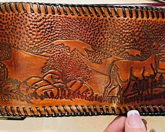 This is a 1950’s - 1970’s vintage hand-tooled leather wallet featuring a fly fishing scene.