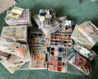 Supplies for jewelry beading, including cases filled with beads, wire, and findings.