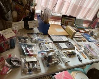 Art table includes oil paints, acrylic paints, watercolors, brushes, pastels, tools, glass chips, canvases, lots of design source material, how-to books, easels, misc tools.