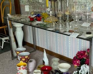 oil lamps, artificial geraniums and violets, flower pots, candle holders, cut-glass electric lamp, flower stand