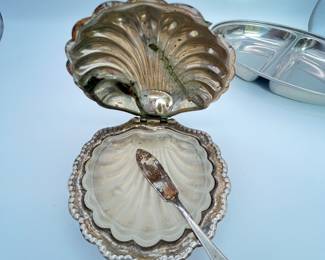 This is a truly unique antique butter dish in the shape of a clam shell with a glass insert and a serving utensil. It is silver plated with some tarnishing and loss of finish. This lot also includes a stainless divided serving tray in excellent condition.
Note photos for details and condition. Measurements taken under field conditions are approximate within 1/2". Feel free to reach out with any questions.