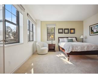 Room shot of upholstered swivel bedroom chair, bedside tables (solid wood) queen size bed with brand new mattress, lamps, mirrors above the bed. Bed frame and headboard solid wood with woven caning on the headboard. Bedding not included.