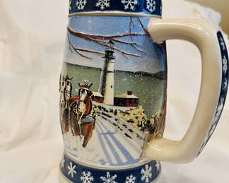 Vtg. 1995 Budweiser Holiday Stein featuring a winter scene with Clydesdale horses and a lighthouse, titled "Lighting the Way Home."