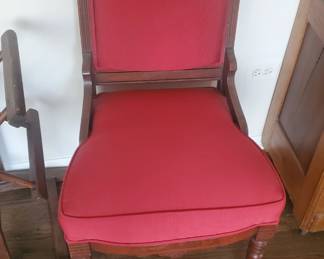1800s Chair with wheels and red fabric to accent the carved wood features