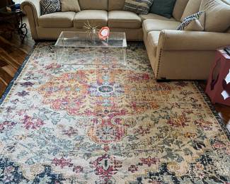 Colorful 8 x 10 rug, plexiglass Coffee Table and khaki sectional