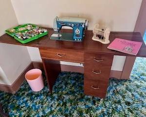 Vintage Singer is complete with console and drawers have surprises too