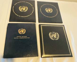 Four portfolios, each with a different United Nations first day cover and stamps. Dates are 1964, 1975, 1986 and 1999.