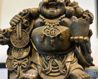 Stone carving by Gary Asmit. Approximately 12" tall. This figure is known for his jolly personality, and symbolizes joy and contentment. The coins, especially when depicted in a chain, as they are here, represent the continous flow of wealth and good fortune.