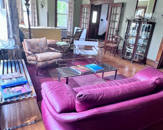 Living room with chrome benches, leather sofa, MCM chairs, Curved glass china cabinet....