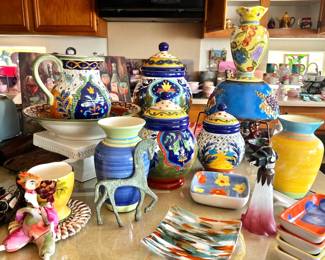 A variety of canisters, covered jars, pitchers, and other colorful pottery and porcelain kitchen items. $5.00 - $25