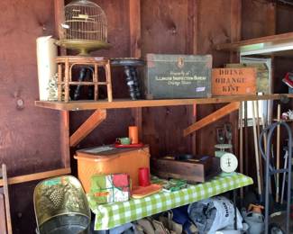 Brass birdcage, vintage wooden stools, boxes with advertising, picnic basket filled with vintage plastic ware, factory mold, old kitchen scale in green