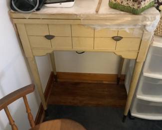 Off white sewing cabinet with antique singer sewing machine.