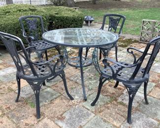 Wrought iron table with glass top and four chairs. Presale $150