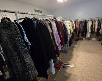 A bedroom full of casual, dressy and fancy clothing.