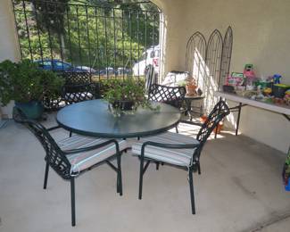 Round glass patio table and 4 chairs with cushions.