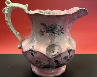 A charming late 19th century pink milk jug with black transfer ware flowers
