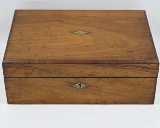 A charming mid-19th century English writing slope, crafted in richly grained walnut with a diamond-shaped mother-of-pearl inlay and matching keyhole escutcheon. The interior features its original purple velvet writing surface, complete with compartments for ink bottles, pens, and paper. The slope opens to reveal multiple writing and storage areas, once used for correspondence and personal documents. Estimated date: 1850s