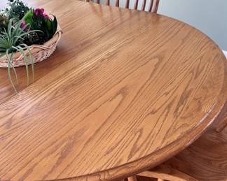 Oak pedestal table with six chairs, two leaves