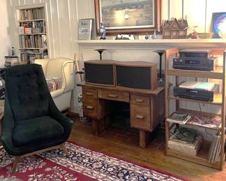 This overview shows a rug and chair shown elsewhere, but also the two Bose 901-series speakers, along with audio components on the shelves, and a framed art piece above the mantle. Little treasures abound in this sale; look everywhere.