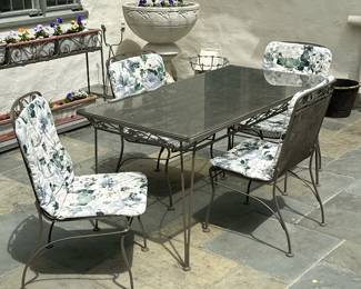 (5pc) PROBABLY WOODARD WROUGHT IRON PATIO DINING SUITE | Wrought iron outdoor/patio furniture, including a rectangular dining table with glass table top insert and four (4) side chairs (no arms) with floral design along the top edge. Similar to Woodard Furniture designs. Includes cushions.
Chairs: h. 36 x w. 19 x d. 22
Dimensions: h. 29.5 x w. 32 x l. 60 in (Table)