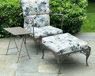 (3pc) Wrought Iron Armchair, Footstool & Side Table #2 | Wrought iron outdoor/patio furniture, including an armchair, matching footstool, and rectangular side table, all with floral designs along the edges. Similar to Woodard Furniture designs. Chair and footstool include cushions. Footstool: h. 12 x w. 22 x d. 24
Table: h. 19 x w. 16 x d. 12.5 - h. 37 x w. 28 x d. 26 in (Chair)