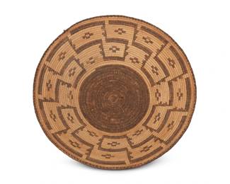 332
A large Pima basketry tray
Early/mid-20th century, Akimel O'odham; Southwest United States
A coiled flared tray with interlocking meandering steps and floating crosses and with a plaited rim
4.375" H x 15" Dia.
Estimate: $700 - $900