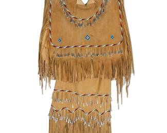230
An Apache contemporary beaded hide dress
Late 20th century
The wearable two-piece buckskin deer hide dress comprising a pullover top with open sides and a straight skirt with hide drawstring, each with long fringing to most edges and decorated with red, blue, white, and black beaded bands and geometric motifs, with silver metal rivets and metal cone dangles throughout, suspended together from a rustic branch
3 pieces
Top: 23" H x 28" W; Fringing: 27" to 7" L approximately; Skirt: 37" H (including fringe) x 22" W; Suspended: 52" L total
Estimate: $500 - $700
