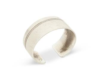 219
An Allison Lee Navajo sterling silver cuff bracelet
Allison Lee (b. 1958, Diné)
Late 20th/early 21st century
Stamped: Allison Lee / L.T.D.
A smooth modernist silver cuff with incised hatched "chain" narrow banding
6.5" total inner C x 1" H, including a 0.875" gap
62.1 grams
Estimate: $300 - $500