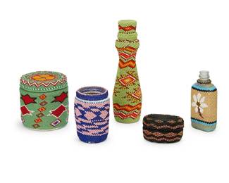 236
A group of Paiute beaded glass and basketry items
Early/mid-20th Century; Great Basin
Five works comprising a tall fully beaded lidded glass bottle in green and orange, a small square glass bottle in blue and gold with a white floral motif, a chunky lidded glass jar in green and red, a small glass jar in blue and pink, and a diminutive oval lidded coiled basket in black, gold and red beads
5 pieces
Largest bottle/jar: 8.25" H x 2.5" Dia.; Smallest: 4.625" H x 2.25" W x 1.25" D; Basket: 1.75" H x 3" W x 2" D
Estimate: $200 - $400