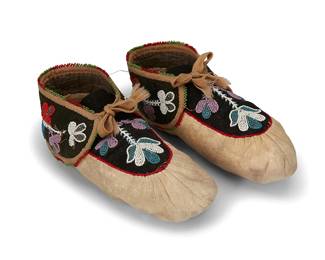 228
A pair of Woodlands beaded moccasins
Early 20th century; likely Anishinaabe (Ojibwe)
Each soft gathered hide moccasin with multicolored floral beadwork to black wool tops and heel bands, including faceted blue and silver beads, with red and green beadwork edging and wool braid trim and ties
2 pieces
10.25" L x 3.5 & 3.75" H x 4.25" W
Estimate: $200 - $400