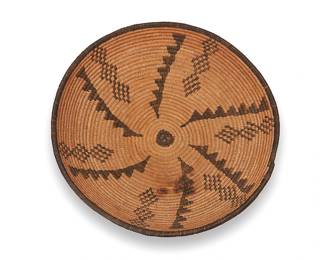 305
An Apache basketry tray
Early 20th century; Southwest United States
A coiled tray with radiating stepped triangles and stacked diamond columns
3.25" H x 12.5" Dia.
Estimate: $300 - $500