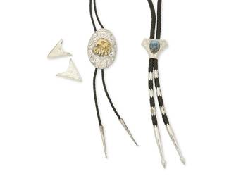 331
A group of Western-style sterling silver bolo ties and accessories
Late 20th century
Variously marked for maker and for sterling
Comprising a "Michael and Sons - Reno" chased silver and gold-toned eagle oval bolo with cone tips, on a braided leather cord, and a chased silver triangular slide bolo with central turquoise cabochon, with pointed silver tips and silver spacers on a thick black braided leather cord, as well as a pair of "Sunset Trails" chased sterling silver collar tips
4 pieces
Bolo slides: 3" H & 1.5" H; cords including drops: 40" L & 38" L; collar tips: 1.5" H
145.2 grams gross
Estimate: $600 - $800