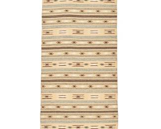 215
A Navajo Chinle textile runner
Mid-20th century, Diné
Woven in sand beige, brown, gray, and cream wool with multiple contrasting striped and geometric bands overall
24.5" H x 59.5" W
Estimate: $400 - $600