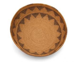 191
A Washoe basketry bowl
Early 20th century; Northern California/Nevada
A coiled gap-stitch low bowl with two concentric serrated zigzag bands and spaced rim ticking
3" H x 9.5" Dia.
Estimate: $200 - $400