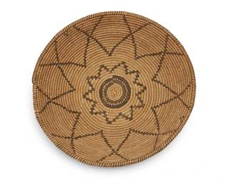 308
An Apache basketry tray
Early 20th century; Southwest United States
A coiled low bowl with central stepped starburst and interlocking radiating star motif, with rim ticking and small ticked band to center.
3' H x 12.5" Dia.
Estimate: $300 - $500