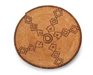 122
A California basketry tray
Early/mid-20th century
The three-rod coiled tray with five contrasting stacked diamond arms issuing from the center
1.75" H x 13.25" Dia.
Estimate: $400 - $600