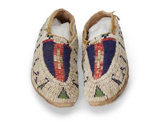 225
A pair of Sioux beaded and quilled hide moccasins
Late 19th century; Northern/Central Plains
Each hide moccasin featuring white, blue, and green beads in geometric motifs, with bands of white and dyed red quill details to front, and ankle areas edged with quillwork
2 pieces
9.75" x 3.5" W and 9.5" L x 3.25" W
Estimate: $400 - $600