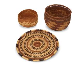 42
A group of Hupa/Yurok/Karuk baskets
Early/mid-20th century; Northern California
Three twined baskets comprising a small bowl with a band of imbricated triangle motifs (3.25" H x 5.5" Dia.), a polychrome flat sifting tray with concentric bands of plain and geometric motifs, with an openwork coiled ticked rim (9.875" Dia.), and a tall polychrome bowl with diagonal stepped pointed motifs and a coiled openwork rim (4.75" H x 6.5" Dia.)
3 pieces
Estimate: $400 - $600