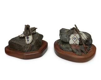 99
Velmalee "Vel" Miller (1936-2025)
Two works:
Moccasins, 1986
Cold-painted and patinated bronze on wood plinth
Edition: 56/75
Signed, dated, and numbered in the casting: Vel Miller ©
Bronze: 3.125" H x 5" W x 3875" D; Overall: 4" H x 6.25" W x 5.125" D
Pipe and Tobacco Bag, 1987
Cold-painted and patinated bronze on wood plinth
Edition: 15/75
Signed, dated, and numbered in the casting: Vel Miller ©
Bronze: 3" H x 6.125" W x 4.75" D; Overall: 3.875" H x 6.875" W x 5.625" D
2 pieces
Estimate: $300 - $500