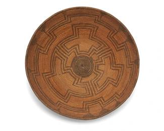 307
An Apache basketry tray
Early 20th century; Southwest United States
A coiled finely stitched flared basket with concentric radiating stepped motifs
3.25" H x 9.75" Dia.
Estimate: $500 - $700