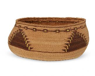 152
A polychrome Klamath basket
Early 20th century; Northern California/Oregon
A twined oval low bowl with four hooked triangle motifs and geometric banding to top, with quillwork imbrication accents, and with hooked bands and bird motif to base
4.25" H x 9.5" Dia. approximately
Estimate: $600 - $900
