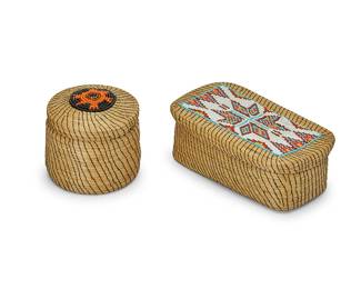 349
Two Great Lakes lidded sweetgrass baskets with beadwork
Early/mid-20th century
Comprising a coiled rectangular box with multicolored geometric beaded panel to lid (2.375" H x 7" W x 4" D), and a round lidded box with medallion motif to top of lid in black and orange (3.5" H x 4" Dia.), each with suede leather base and/or lining
2 pieces
Estimate: $200 - $400