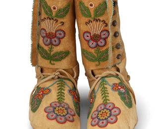 229
A pair of Blackfoot beaded hide high-top moccasins
Late 19th/early 20th century; Great Plains
A pair of elaborately beaded tall buckskin leather moccasins, each with multicolored floral and foliate elements throughout, fine pale blue bead edging, drawstrings to ankles, and silver button side closures
2 pieces
Each: 8.5" H x 3.5" W x 9.5" D approximately
Estimate: $300 - $500