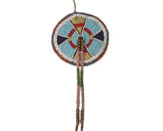232
A Crow beaded hide bag
19th century or later, Apsáalooke; Northern Plains
A round beaded hide bag worked to one side in blue, white, orange, and yellow beads in geometric motifs and with a central pink and green beaded tassel with brass-toned bead accents
4.5" Dia.; tassel: 8.25" L
Estimate: $500 - $700
