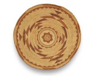 44
A large polychrome Hupa/Yurok/Karuk basketry tray
Early 20th century; Northern California
A twined tray with imbricated overlay stepped triangle motifs, a floral/star center and triangular banding to edge, all worked to the interior
3.5" H x 15" Dia.
Estimate: $400 - $600