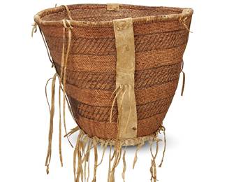 314
A large Apache burden basket
Late 19th century; Southwest United States
A tapered twined basket with striped banding, hide strapping to rim and body, and with hide reinforcement to underside and hide fringe accents
14" H x 15.5" W x 16.5" D
Estimate: $400 - $600