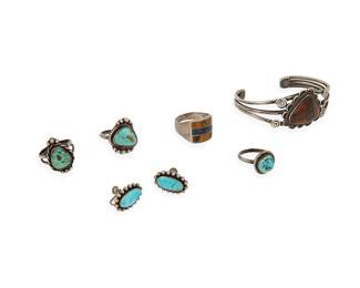 360
A group of Southwest silver and stone set jewelry
Mid/late 20th century
Earrings partially marked for sterling; one ring stamped: 925 / J_M / Mexico
Six works comprising a three-wire cuff with set petrified wood and filigree wire accents, together with three silver and set turquoise rings, a Mexican sterling silver ring with lapis lazuli and tiger's eye inlay, and a pair of diminutive sterling silver and set turquoise earrings
7 pieces
Cuff: 6.125" inner C x 1" H, with a 1.125" gap; ring sizes: 10 to 6.5; earrings: 0.75" H
55.7 grams gross
Estimate: $150 - $250