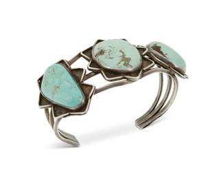 218
A Southwest sterling silver and turquoise cuff bracelet
Mid-20th century
Unmarked
A three-wire cuff with three turquoise cabochons each set to a star-shaped shadowbox plaque
6.625" total inner C x 1.375" H, including a 1.25" gap
47.5 grams gross
Estimate: $400 - $600